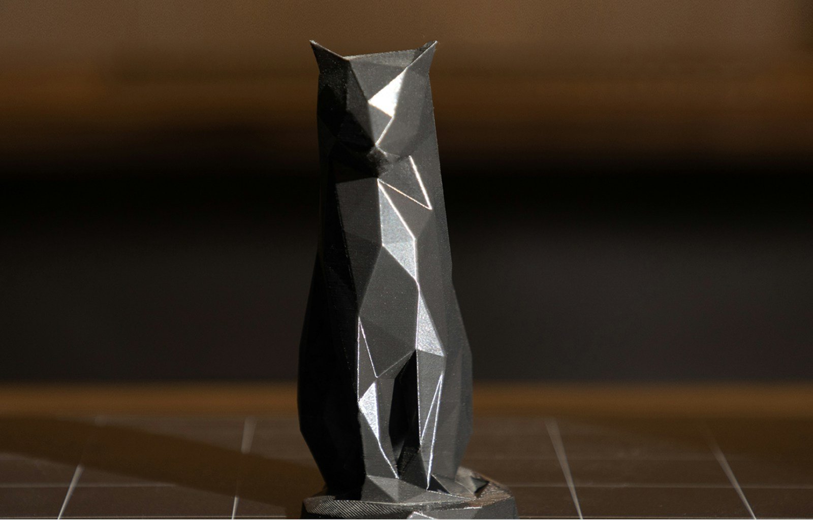 A black and silver vase sitting on top of a tiled floor