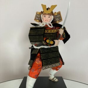a figurine of a man dressed as a samurai holding a sword